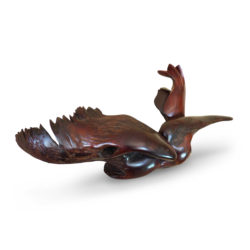 Swamp Seraph Swamp Seraph, the wood sculpture shows a powerful seated bird with large wings and a long beak from the side angle.