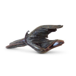 Gotcha! Sculpture titled Gotcha! in dark brown, almost black Mopane wood. A bird is catching a fish, not strictly figurative. The wings of the bird, the open beak and the fish are all emerging out of the waves of the water.